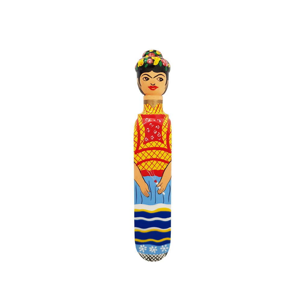 The Wedgie FRIDA Door Stopper by Wedgie is a colorful Alstonia wood piece, hand-painted with durable matte paint, featuring a stylized woman in vibrant attire and bold details on a black background.